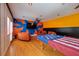 Wide view of spacious game room with hardwood floors and colorful accents on the walls at 3030 Cedar Trce, Tarpon Springs, FL 34688