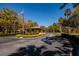 Community entrance featuring a central gazebo, landscaped island, and an American flag waving in the breeze at 3062 Eastland Blvd # 402, Clearwater, FL 33761