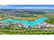 Stunning aerial view of a neighborhood with a large lagoon, beach, and palm trees, perfect for resort-style living at 30753 Penny Surf Loop, Wesley Chapel, FL 33545