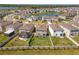 An aerial perspective showing the home's backyard and surrounding community with a central pond at 30753 Penny Surf Loop, Wesley Chapel, FL 33545