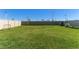 Expansive backyard featuring well-maintained lawn, a fence, and an area for outdoor activities at 30753 Penny Surf Loop, Wesley Chapel, FL 33545