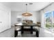 Dining room with unique pendant lighting, seating for six, and sliding door to the backyard at 30753 Penny Surf Loop, Wesley Chapel, FL 33545