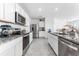 Bright kitchen featuring stainless steel appliances, granite countertops, and sleek white cabinetry at 30753 Penny Surf Loop, Wesley Chapel, FL 33545