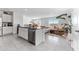 A kitchen island with stainless steel dishwasher opens to a living room with modern design at 30753 Penny Surf Loop, Wesley Chapel, FL 33545