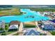 Aerial view of a neighborhood lagoon, featuring clear blue water, waterslides, and beachside cabanas at 30753 Penny Surf Loop, Wesley Chapel, FL 33545