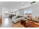Open-concept living room with tile floors, large windows, and a dining area, perfect for entertaining at 30753 Penny Surf Loop, Wesley Chapel, FL 33545