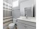 Clean bathroom featuring a vanity with quartz countertop, toilet, shower with a gray striped curtain, and neutral color scheme at 318 Blackrock Ln, Apollo Beach, FL 33572