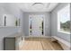 Bright foyer with a modern light fixture, a decorative mirror, and wood-look floors at 318 Blackrock Ln, Apollo Beach, FL 33572