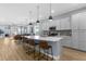 Open-concept kitchen with a large island, seating, stainless steel appliances, and seamless flow into the dining and living areas at 318 Blackrock Ln, Apollo Beach, FL 33572