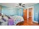 Comfortable bedroom with wooden floors, floral bedding, blue walls, and an open doorway at 330 42Nd S Ave, St Petersburg, FL 33705