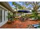 A backyard boasts a brick patio with an outdoor dining set and lounge seating at 3308 W San Nicholas St, Tampa, FL 33629