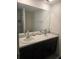 Bathroom with double sinks, a large mirror, and dark cabinets providing ample space at 36562 Silver Maize Dr, Dade City, FL 33525