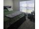 Cozy bedroom featuring a dark wood frame bed with drawers and soft, neutral bedding at 36562 Silver Maize Dr, Dade City, FL 33525