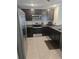 Modern kitchen featuring stainless steel appliances and dark cabinets at 36562 Silver Maize Dr, Dade City, FL 33525