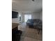 Cozy living room featuring a comfortable sectional sofa and sliding glass doors to the backyard at 36562 Silver Maize Dr, Dade City, FL 33525