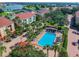 Aerial view of community featuring swimming pool, lush landscaping, red-tiled roofs, and waterfront views of the area at 406 Sandy Hook Rd, Treasure Island, FL 33706