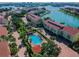 Community aerial view showcasing a pool, landscaping, and residential buildings, with a bay and marina in the background at 406 Sandy Hook Rd, Treasure Island, FL 33706