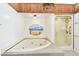 Bathroom featuring a garden tub and glass shower with light-colored textured floor at 406 Sandy Hook Rd, Treasure Island, FL 33706