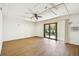 Bright bonus room with new wood floors, ceiling fan, and sliding glass doors that lead to a patio at 406 Sandy Hook Rd, Treasure Island, FL 33706