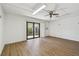 Bright bonus room with new wood floors, ceiling fan, and sliding glass doors that lead to a patio at 406 Sandy Hook Rd, Treasure Island, FL 33706