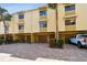 Inviting townhome showcasing a brick driveway, attached garages, and tropical palm tree landscaping at 406 Sandy Hook Rd, Treasure Island, FL 33706
