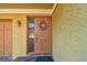 Inviting front door with a decorative wreath, textured wall, and brick walkway at 406 Sandy Hook Rd, Treasure Island, FL 33706