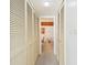 Hallway with white louvered closet doors leads to a white and wood paneled bathroom at 406 Sandy Hook Rd, Treasure Island, FL 33706