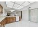 Open kitchen with wood cabinets, white appliances, and tile floor adjacent to living room at 406 Sandy Hook Rd, Treasure Island, FL 33706