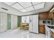 Kitchen featuring wood cabinets, white appliances, tile floor, and breakfast nook with window views at 406 Sandy Hook Rd, Treasure Island, FL 33706