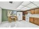 Kitchen featuring wood cabinets, white appliances, tile floor, and breakfast nook with window views at 406 Sandy Hook Rd, Treasure Island, FL 33706