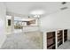 Living room adjacent to the kitchen, boasting neutral carpet and an open, airy atmosphere at 406 Sandy Hook Rd, Treasure Island, FL 33706