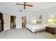 This is a view of the carpeted main bedroom with bright natural light and a ceiling fan at 406 Sandy Hook Rd, Treasure Island, FL 33706