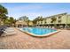 Community pool with clear blue water, ample lounge chairs, and a covered pavilion surrounded by lush tropical landscaping at 406 Sandy Hook Rd, Treasure Island, FL 33706