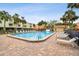 Resort-style pool surrounded by lush landscaping and comfortable lounge chairs at 406 Sandy Hook Rd, Treasure Island, FL 33706