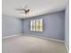 Large bedroom featuring a ceiling fan, light blue walls, and a window with plantation shutters at 5014 W Lancaster St, Tampa, FL 33616