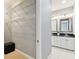 Walk-in closet and bathroom featuring a double vanity sink and ample storage space at 5014 W Lancaster St, Tampa, FL 33616