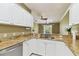 Well-lit kitchen featuring granite countertops and white cabinetry, perfect for cooking and entertaining at 5014 W Lancaster St, Tampa, FL 33616
