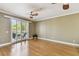 Spacious living room featuring hardwood floors, a ceiling fan, and sliding glass doors to the balcony at 5014 W Lancaster St, Tampa, FL 33616