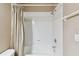 Bathroom features a shower and tub combination and neutral toned shower curtain at 5014 W Lancaster St, Tampa, FL 33616