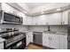 Bright kitchen boasts stainless steel appliances, granite countertops, white cabinets and custom backsplash at 5200 Brittany S Dr # 1503, St Petersburg, FL 33715