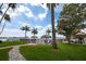 Tranquil beachfront pool area featuring palm trees, lounge chairs, and well maintained landscaping at 5200 Brittany S Dr # 1503, St Petersburg, FL 33715