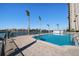 Exterior view of a refreshing community pool with waterfront views and tall palm trees at 5200 Brittany S Dr # 1503, St Petersburg, FL 33715