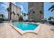 Resort style pool with tropical landscaping, sun loungers, and ocean views at 5200 Brittany S Dr # 1503, St Petersburg, FL 33715