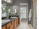 This bathroom features double sinks, wood cabinets, neutral walls, and a window with a view at 555 52Nd N Ave, St Petersburg, FL 33703