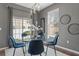 Dining area with a modern glass table, blue velvet chairs, and contemporary light fixtures at 555 52Nd N Ave, St Petersburg, FL 33703