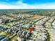 Expansive aerial view showcasing the neighborhood with community pool, surrounding trees, and a glimpse of a nearby lake at 6002 Thrushwood Rd, Lithia, FL 33547