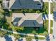Aerial rooftop view of a single-Gathering home with screened in porch surrounded by tropical landscaping at 6002 Thrushwood Rd, Lithia, FL 33547