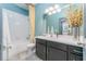 Bright bathroom with a white tiled shower, a dark vanity, and a large mirror at 6002 Thrushwood Rd, Lithia, FL 33547
