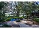 Communal fire pit surrounded by landscaping and blue chairs offers a peaceful outdoor space at 6002 Thrushwood Rd, Lithia, FL 33547