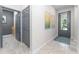 Bright entryway featuring neutral walls, gray trim, tile floors, and a storm door letting in natural light at 6002 Thrushwood Rd, Lithia, FL 33547